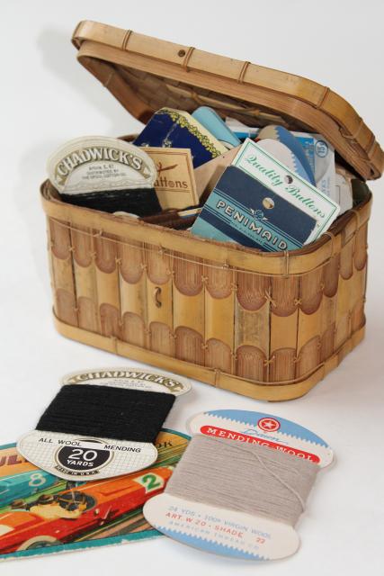 basket full of vintage sewing notions, needle books, carded yarn, thread, buttons