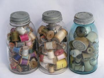 big antique glass jars full of old silk, cotton thread, vintage wood spools