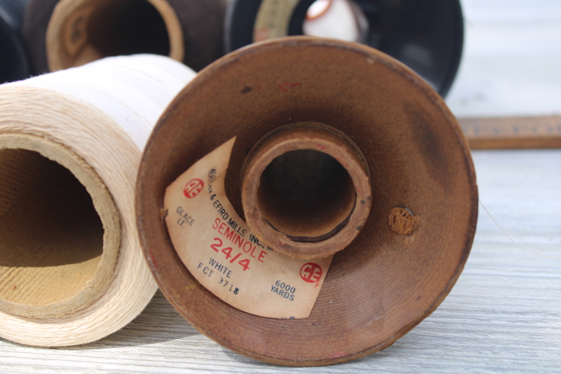 lot old industrial spools of thread, grubby white, black, neutral colors for rustic vintage display
