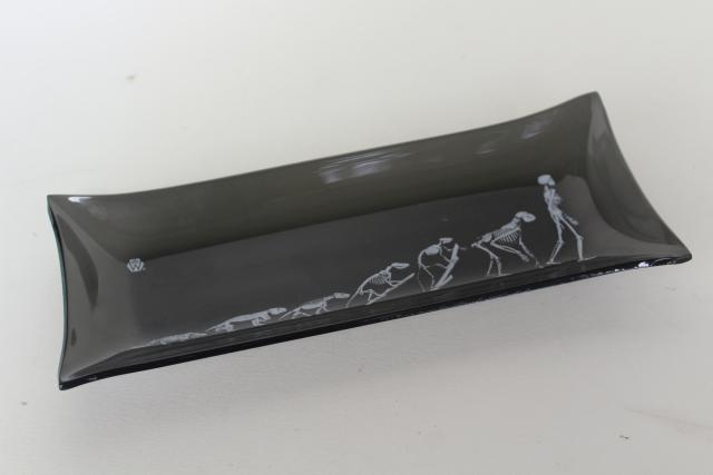 mod vintage black smoke formed glass tray, skeletons lizard to man evolution