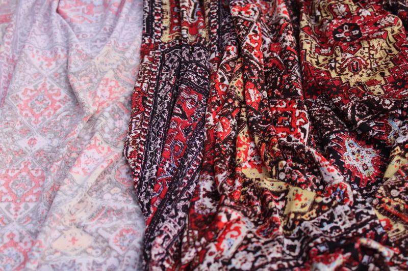 modern boho style slinky poly knit fabric, reds browns print patchwork of oriental rug patterns