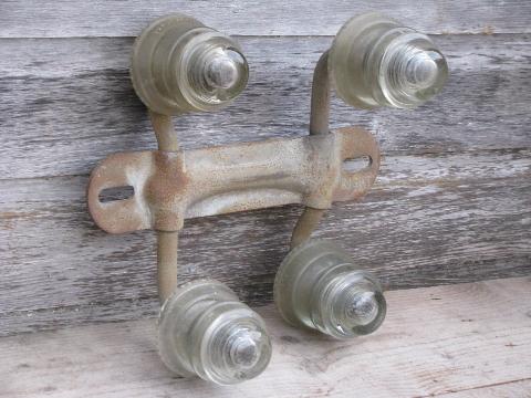 primitive harness or coat hook pegs, antique glass insulators on steel bracket rack