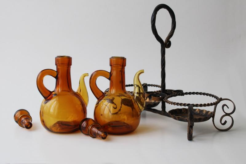 vintage hand blown glass cruet set, amber glass pitchers & stoppers in wrought iron stand