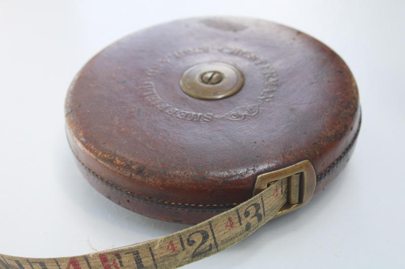 antique Chesterman 100 foot cloth tape measure in leather case, brass hand crank winding reel