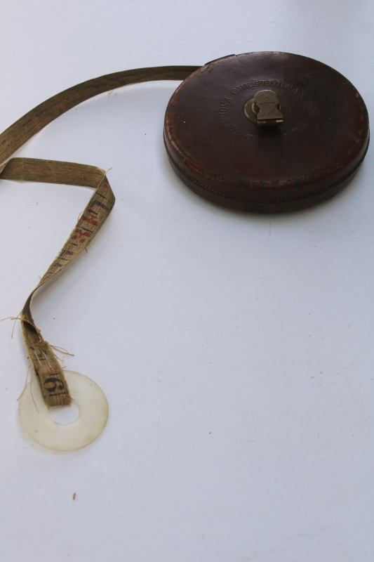 antique Chesterman 100 foot cloth tape measure in leather case, brass hand crank winding reel