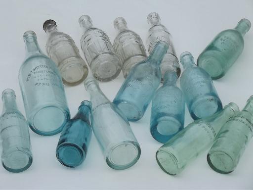 collection of old soda & water bottles, heavy clear glass & aqua blue glass bottles