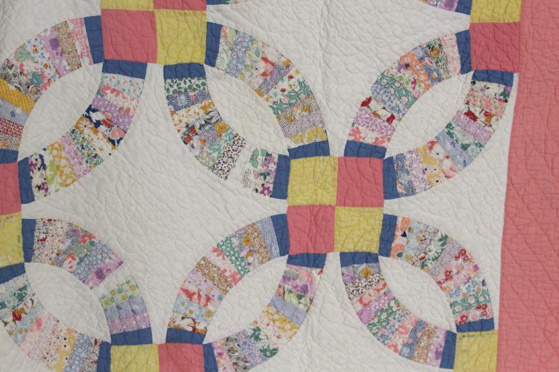 hand-stitched double wedding ring quilt, vintage cotton print fabrics w/ pink border