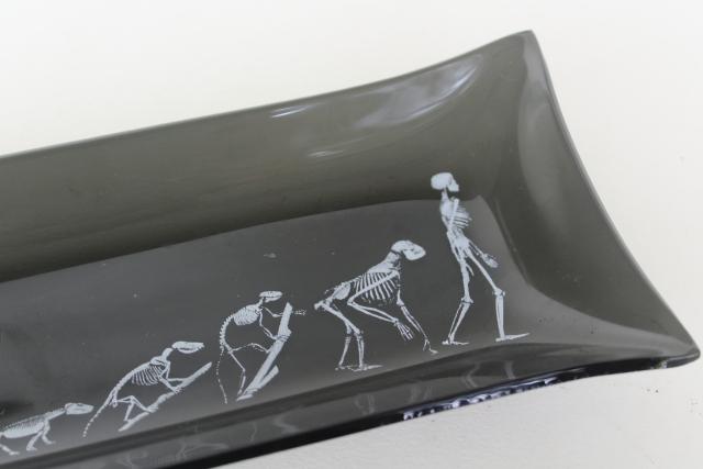 mod vintage black smoke formed glass tray, skeletons lizard to man evolution