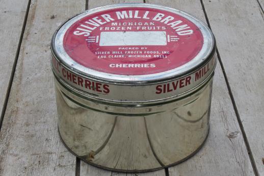 old cherry tin full of vintage cookie cutters, small jello molds, doughnut dropper