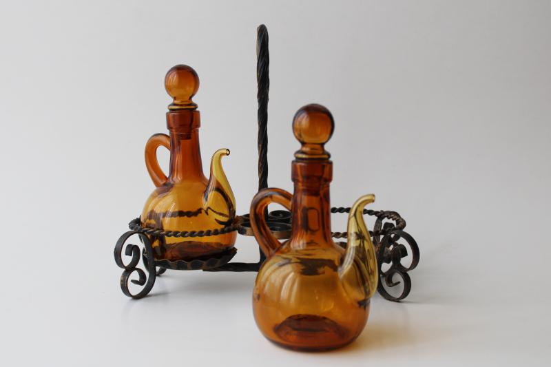 vintage hand blown glass cruet set, amber glass pitchers & stoppers in wrought iron stand