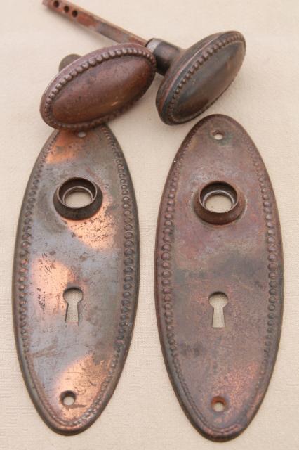 vintage oval door knobs  beaded edge back plates,   antique tiger stripe japanned copper finish