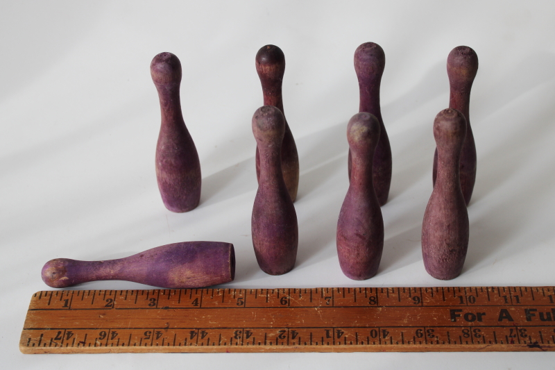 vintage wood skittles pins or bowling toy pieces, worn weathered purple color