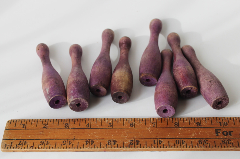 vintage wood skittles pins or bowling toy pieces, worn weathered purple color