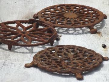 catalog photo of antique rusty iron trivets, primitive vintage round trivet collection