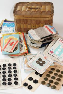 catalog photo of basket full of vintage sewing notions, needle books, carded yarn, thread, buttons