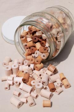 catalog photo of big old herring barrel glass jar full of tiny wooden spools, wood spool lot