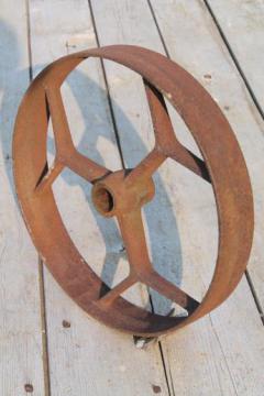 catalog photo of big old iron fly wheel from steampunk vintage industrial machinery or farm equipment