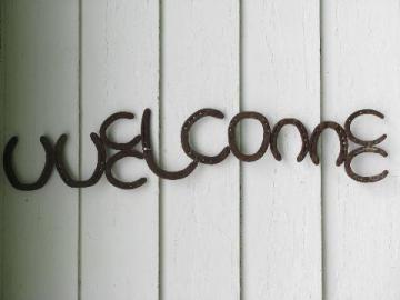 catalog photo of big rustic western ranch Welcome sign, old wrought iron horseshoe letters