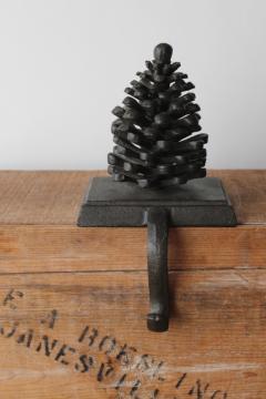 catalog photo of cast iron pinecone Christmas stocking hanger or wreath holder, modern rustic holiday decor 