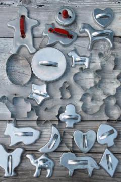 catalog photo of lot of vintage metal cookie cutters, old aluminum cookie cutters w/ red handles etc.