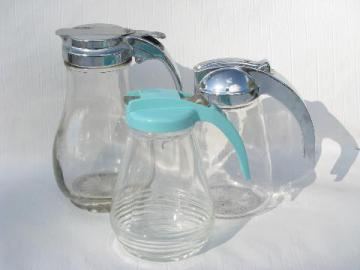 catalog photo of lot of vintage syrup pitchers, glass jars, chrome or aqua plastic lids