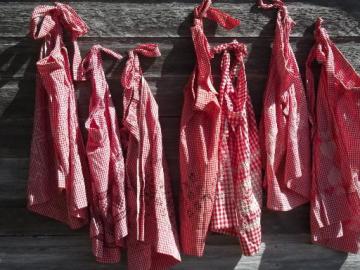 catalog photo of lot vintage red and white checked gingham half aprons, one for each day of the week