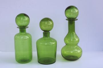 catalog photo of mod style green glass decanters, trio of tall bubble seeded glass bottles w/ stoppers 