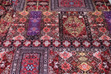 catalog photo of modern boho style slinky poly knit fabric, reds browns print patchwork of oriental rug patterns