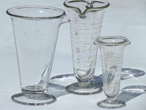 photo of old antique lab glass beakers, graduated size pharmacy bottle measures #1