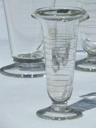 photo of old antique lab glass beakers, graduated size pharmacy bottle measures #2