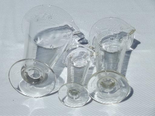 photo of old antique lab glass beakers, graduated size pharmacy bottle measures #6