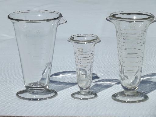 photo of old antique lab glass beakers, graduated size pharmacy bottle measures #7