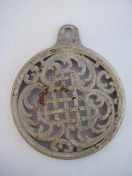 catalog photo of old antique ornate cast iron tea kettle trivet, made to hang on the wall