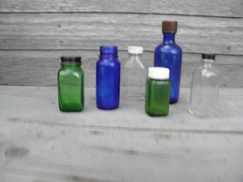 photo of old clear, cobalt, green glass medicine bottles, bakelite, metal lids #1
