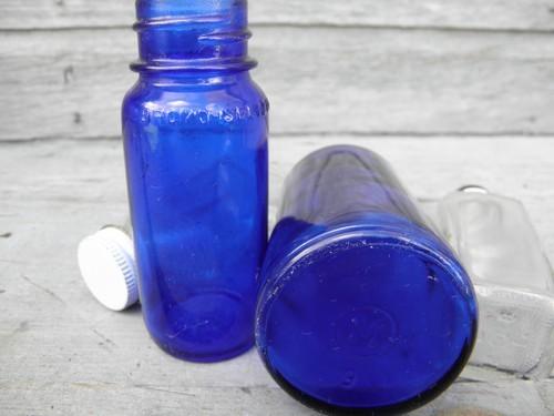 photo of old clear, cobalt, green glass medicine bottles, bakelite, metal lids #2