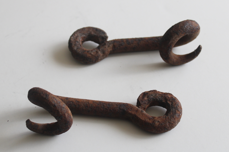 photo of old hand forged iron pigtail hooks, rusty antique hardware rope guides from farm equipment  #1