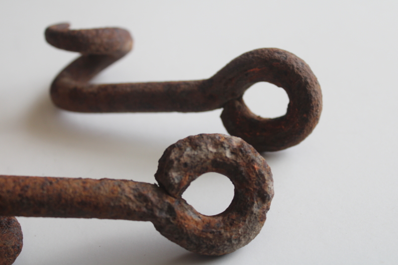 photo of old hand forged iron pigtail hooks, rusty antique hardware rope guides from farm equipment  #4