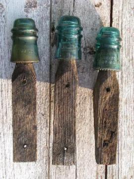 catalog photo of primitive harness or coat hooks, old barn board wood pegs w/ antique glass insulators