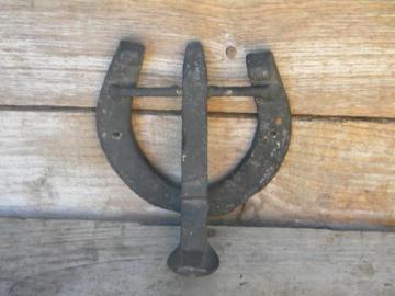 catalog photo of primitive iron door knocker made from horseshoe and railroad spike