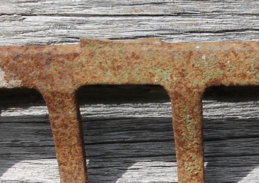 photo of primitive iron wall rack from rusty old cast iron grill part from wood burning or coal stove  #8