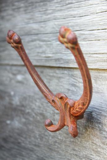 photo of rusty old antique iron coat hook, ornate vintage cast iron hardware double hook #2