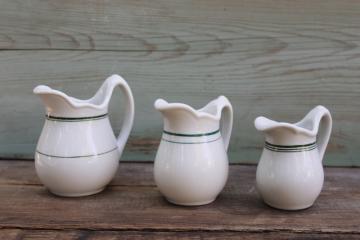 catalog photo of trio of vintage ironstone china pitchers, chunky creamers stair step sizes green band patterns 