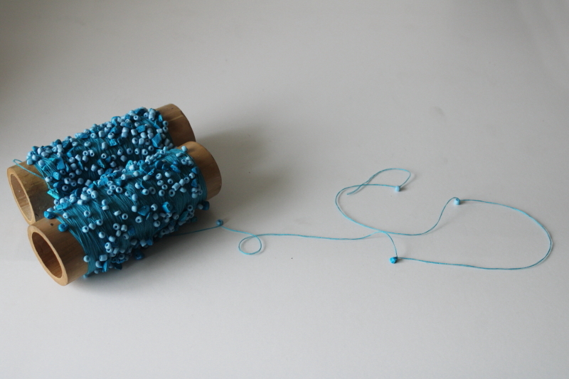 photo of turquoise glass seed beads threaded knotted on cotton crochet thread, hand beaded yarn  #1