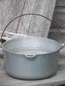 catalog photo of vintage aluminum dutch oven w/ bail handle, rough camping / campfire pot