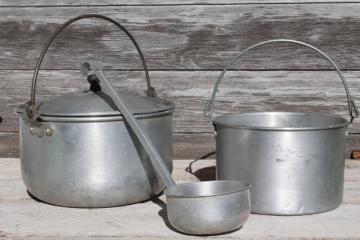 catalog photo of vintage camp cookware, aluminum camping pots w/ wire handles, cooking kettles w/ dipper