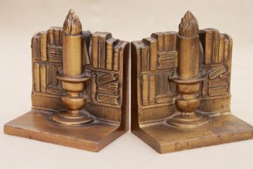 catalog photo of vintage cast metal bookends w/ antique brass finish, book & candle stick stacks of books