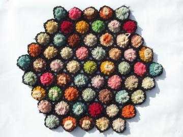 catalog photo of vintage crochet wool yarn table mat, bright fluff flowers w/ blac