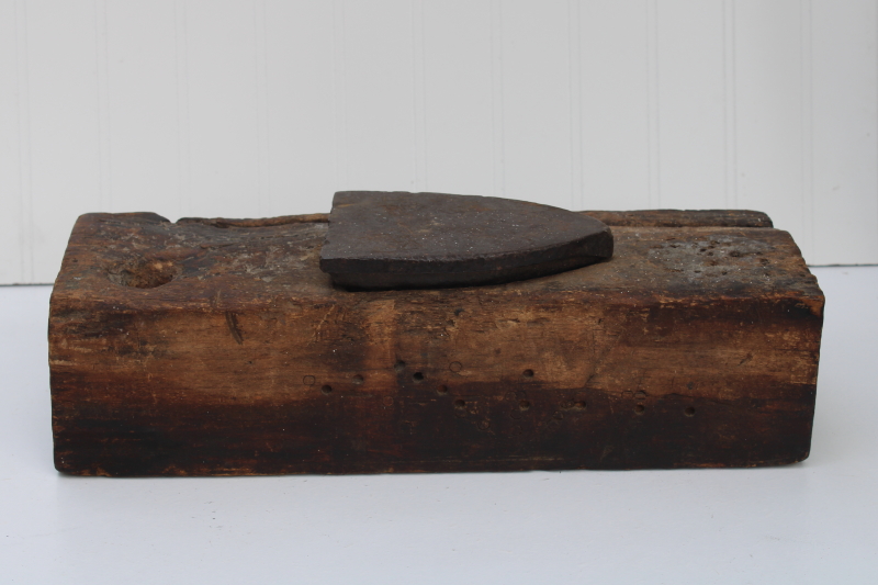 photo of vintage depression era make do anvil, antique clothes iron set in a large old wood barn beam #1