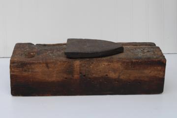 photo of vintage depression era make do anvil, antique clothes iron set in a large old wood barn beam