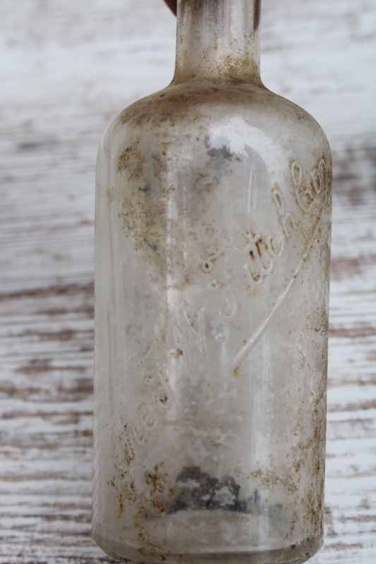 photo of vintage embossed glass medicine bottles, spooky old dug bottles for creepy haunted Halloween #3
